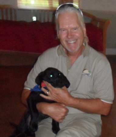 Makana Aloha founder, Gunars Valkirs with a puppy in training at Assistance Dogs of Hawaii